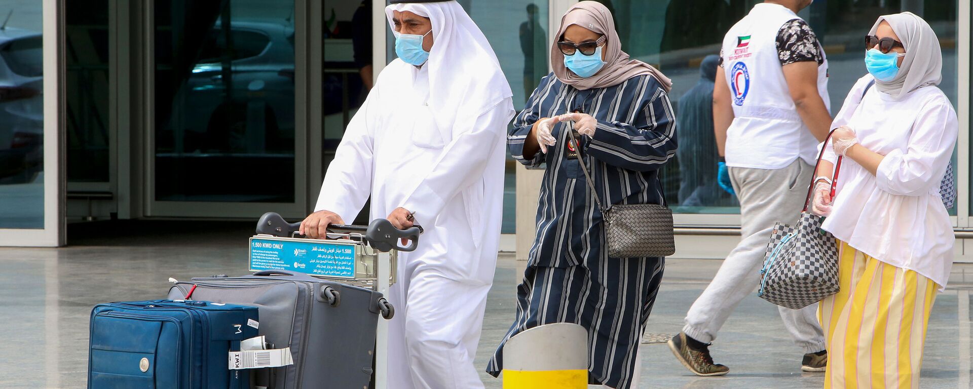 يغادر المواطنون الكويتيون المقيمون في الخارج مطار الكويت الدولي في العاصمة عند عودتهم كجزء من خطة الإعادة إلى الوطن في 19 أبريل 2020 ، وقبل نقلهم إلى الحجر الصحي الإلزامي - سبوتنيك عربي, 1920, 18.03.2021