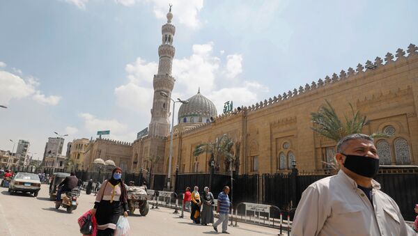 رجل يرتدي كمامة واقية من فيروس كورونا يسير أمام مسجد السيدة زينب المغلق - سبوتنيك عربي