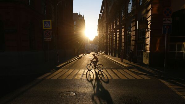 راكب دراجة هوائية يعبر شارع غالوتفينسكي على خلفية غروب الشمس في موسكو - سبوتنيك عربي