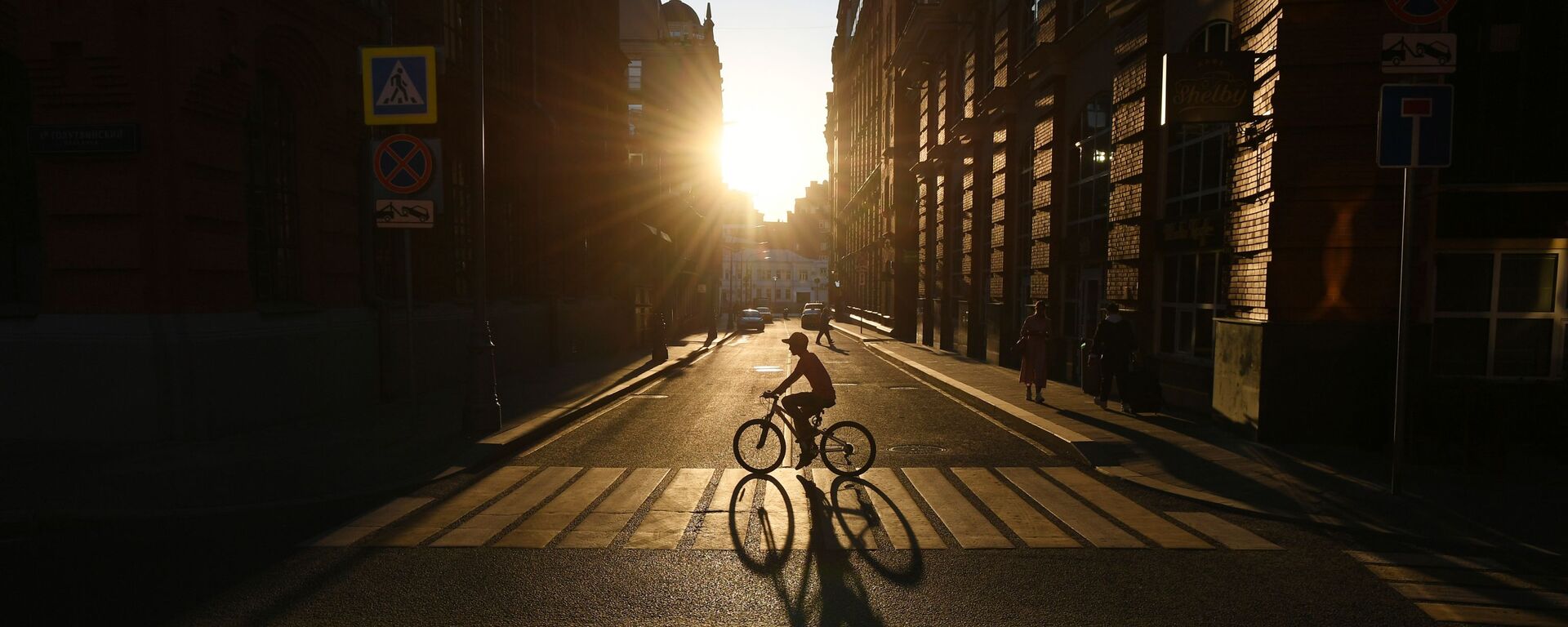 راكب دراجة هوائية يعبر شارع غالوتفينسكي على خلفية غروب الشمس في موسكو - سبوتنيك عربي, 1920, 25.08.2020