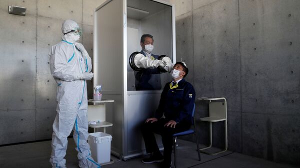 عامل طبي يجري محاكاة لاختبار مرض فيروس كورونا (COVID-19) في منشأة مؤقتة في يوكوسوكا جنوب طوكيو في اليابان  - سبوتنيك عربي