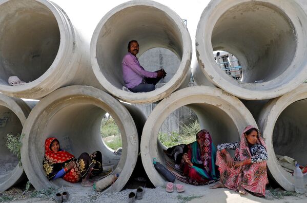 عمال مهاجرون يستريحون في أنابيب إسمنتية، خلال الإغلاق التام على مستوى الدولة، لإبطاء انتشار مرض فيروس كورونا (كوفيد-19) في لكناو، الهند ، 22 أبريل 2020. - سبوتنيك عربي