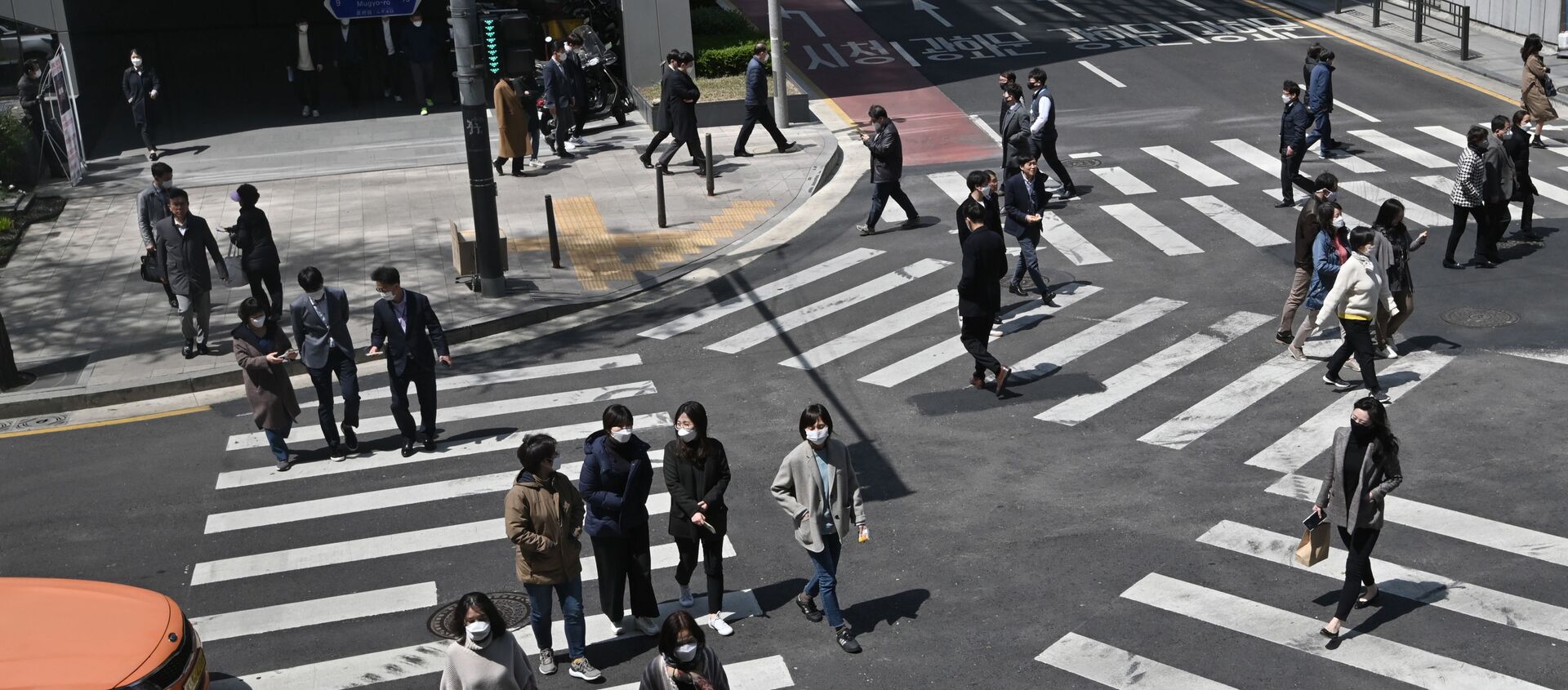 أشخاص مقنعون يعبرون مفترق طرق عند معابر المشاة في سئول، كوريا الجنوبية  23 أبريل 2020 - سبوتنيك عربي, 1920, 09.02.2021