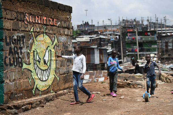 طفل صغير يقرأ الرسالة من لوحة جدارية توعوية تحذر الناس من خطر مرض كوفيد-19 الذي يسببه الفيروس كورونا، في حي وادي ماثاري في نيروبي، كينيا 22 أبريل 2020. - سبوتنيك عربي
