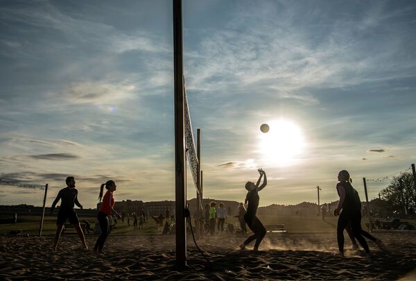 يلعب الناس الكرة الطائرة الشاطئية في حديقة غارديت للترفيه، وسط تفشي مرض التاجية (كوفيد-19)، في ستوكهولم، السويد، 20 أبريل 2020. - سبوتنيك عربي