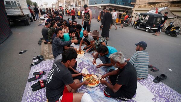 عراقيون خلال الإقطار في شوارع ميدان تحرير في بغداد، شهر رمضان، العراق 25 أبريل 2020 - سبوتنيك عربي
