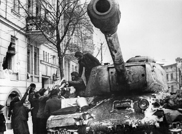 أهالي مدينة بوزنان المحرر من ألمانيا النازية، يرحبون بالجنود السوفيتيين على متن الدبابة الثقيلة إي إس-2 (دبابة يوسف ستالن)، بولندا 23 فبراير 1945 - سبوتنيك عربي
