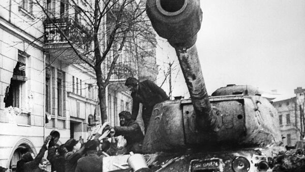 أهالي مدينة بوزنان المحرر من ألمانيا النازية، يرحبون بالجنود السوفيتيين على متن الدبابة الثقيلة إي إس-2 (دبابة يوسف ستالن)، بولندا 23 فبراير 1945 - سبوتنيك عربي
