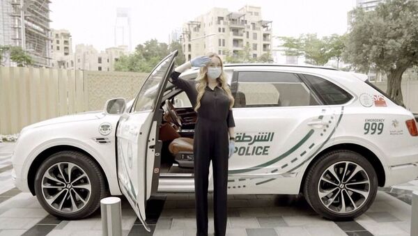 الممثلة الأمريكية ليندسي لوهان بالقرب من سيارة الشرطة الإماراتية  - سبوتنيك عربي
