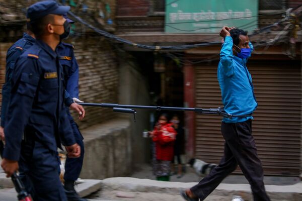 شرطي أثناء اعتقال رجل خالف نظام الحجر الصحي بأحد شوارع كاتماندو، نيبال 6 أبريل 2020 - سبوتنيك عربي