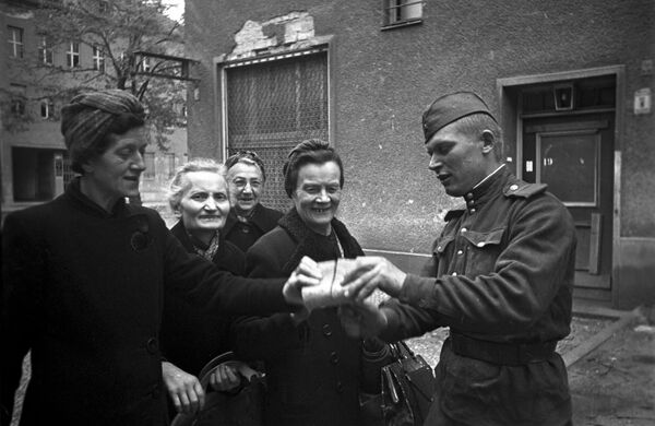 صور من أرشيف الحرب الوطنية العظمى (1941 - 1945) - جندي سوفيتي يوزع الخبز على نساء برلين، 7 مايو/ أيار 1945 - سبوتنيك عربي