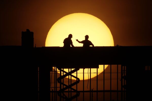 رجلان على خلفية طلوع الشمس في كانساس-سيتي، ولاية ميزوري، الولايات المتحدة 8 أبريل 2020 - سبوتنيك عربي