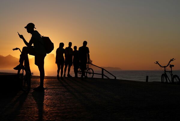 مواطنون يتحدون الحجر الصحي ويتوجهون إلى شاطئ ريسيريو دوس بانديرانتيس في وقت طلوع الشمس في ريو دي جانيرو، البرازيل 25 أبريل 2020 - سبوتنيك عربي
