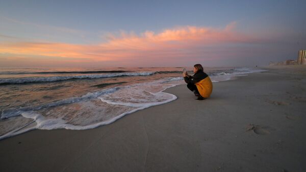 فتاة على شاطئ أورنج بيتش المطلة على خليج المكسيك، الولايات المتحدة 13 مارس 2020 - سبوتنيك عربي
