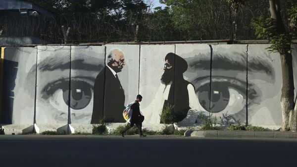 صبي صغير يحمل كيسًا من البضائع على ظهره يمشي خلف جدار في كابول في أفغانستان يصور مبعوث واشنطن للسلام زلماي خليل زاد والملا عبد الغني بارادار رئيس وفد طالبان - سبوتنيك عربي