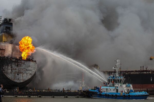 رجال إطفاء يحاولون إطفاء حريق على سفينة ناقلة راسية في بالاوان، إندونيسيا 11 مايو/ أيار 2020. - سبوتنيك عربي