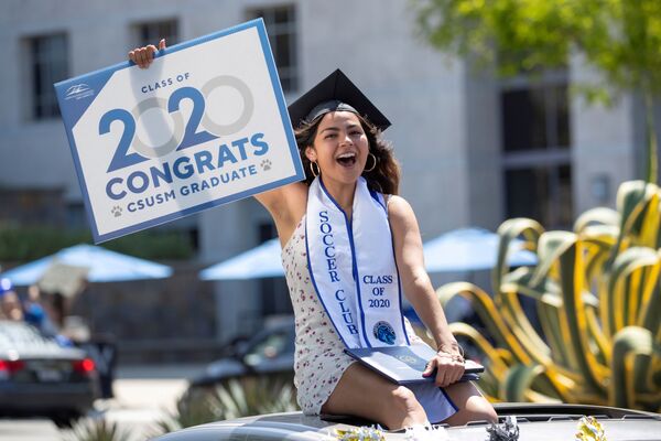 خريجة من جامعة ولاية كاليفورنيا في سان ماركوس، تحتفل بتخرجها في سيارة أمام الحرم الجامعي أثناء تفشي مرض فيروس كورونا (كوفيد-19) في سان ماركوس، كاليفورنيا، الولايات المتحدة، 15 مايو 2020. - سبوتنيك عربي