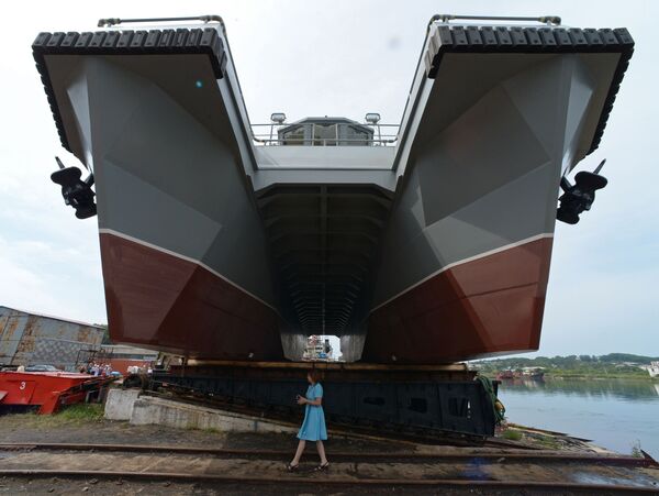 امرأة تقف أمام قارب مشروع 23370 متعدد المهام بمصنع ليفادييسكي لإصلاح وبناء السفن، مصمم لطاقم الإنقاذ التابع لأسطول المحيط الهادئ، قبل بدء مراسم الإنزال في إقليم بريمورسكي كراي - سبوتنيك عربي