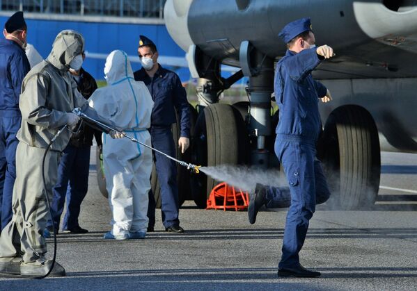 تعقيم أفراد الفريق الطبي العسكري بعد وصولهم من إيطاليا إلى روسيا، 15 مايو 2020 - سبوتنيك عربي