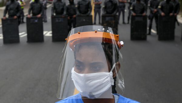 أحد سكان بارايسوبوليس، أحد أكبر الأحياء الفقيرة في مدينة ساو باولو، أقناء الاحتجاجات في البرازيل 18 مايو 2020، للمطالبة بمزيد من المساعدات من حكومة ولاية ساو باولو خلال جائحة فيروس كورونا. - سبوتنيك عربي