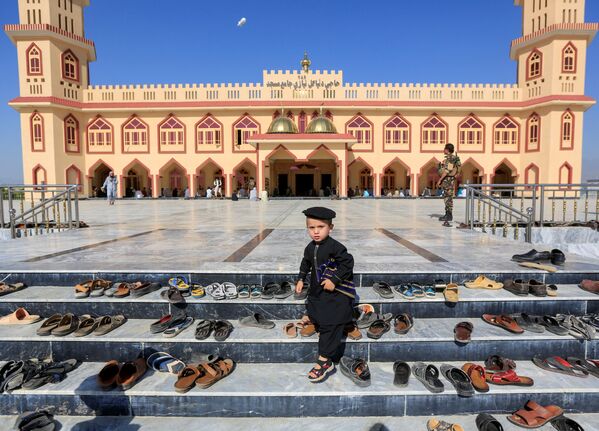 طفل خارج مسجد أثناء صلاة عيد الفطر في مسجد في ولاية لغمان، رغم انتشار فيروس كورونا في أفغانستان 24 مايو 2020 - سبوتنيك عربي