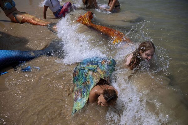 أعضاء جماعة حوريات البحر الإسرائيلية يرتدون ذيل عروس البحر على شاطئ البحر في بات يام، بالقرب من تل-أبيب، إسرائيل، 23 مايو/ أيار 2020. - سبوتنيك عربي