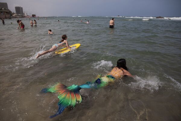 أعضاء جماعة حوريات البحر الإسرائيلية يرتدون ذيل عروس البحر على شاطئ البحر في بات يام، بالقرب من تل-أبيب، إسرائيل، 23 مايو/ أيار 2020.  - سبوتنيك عربي