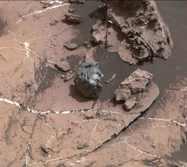 صورة لصخرة ملساء داكنة اللون، التقطتها كاميرا تصوير ماست كاميرا (Mast Camera) المثبتة على المركبة المتجولة على المريخ كيوريوسيتي روفر‏، والتي أثبتت تحليلها الحاسوبي أن الصخرة جزء من نيزك مكوانته الحديد والنيكل. 30 أكتوبر/ تشرين أول  2016 - سبوتنيك عربي