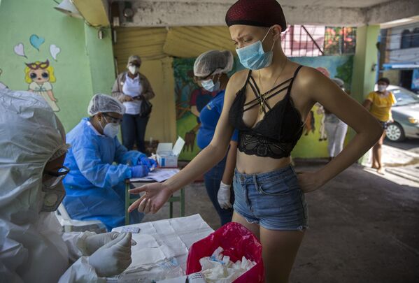 امرأة أثناء القيام بالاختبار السريع لمرض كوفيد-19، الذي يجريه موظفو وزارة الصحة العامة في حي دي فيبيرو في سانتو دومينغو، جمهورية الدومنيكان  في 25 مايو/ أيار 2020. - سبوتنيك عربي