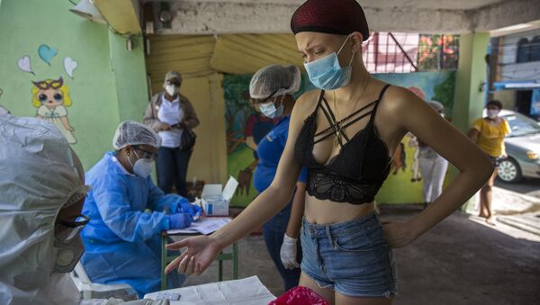 امرأة أثناء القيام بالاختبار السريع لمرض كوفيد-19، الذي يجريه موظفو وزارة الصحة العامة في حي دي فيبيرو في سانتو دومينغو، جمهورية الدومنيكان  في 25 مايو/ أيار 2020. - سبوتنيك عربي