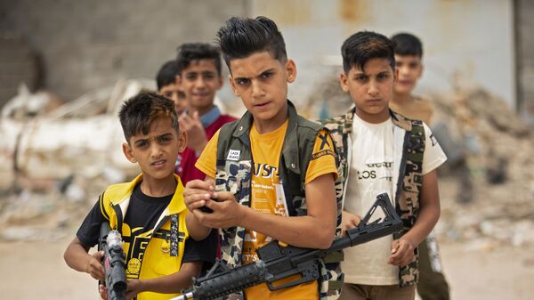 أطفال يلعبون بالمسدسات والبنادق االبلاستيكية في يوم عيد الفطر في البصرة، العراق 25 مايو/ أيار 2020 - سبوتنيك عربي