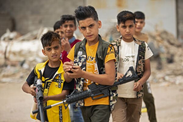 أطفال يلعبون بالمسدسات والبنادق االبلاستيكية في يوم عيد الفطر في البصرة، العراق 25 مايو/ أيار 2020 - سبوتنيك عربي