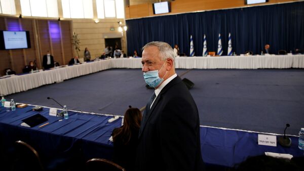 يرتدي وزير الدفاع الإسرائيلي ورئيس الوزراء المناوب بيني غانتس قناعًا لدى وصوله إلى الاجتماع الأسبوعي للحكومة في القدس - سبوتنيك عربي