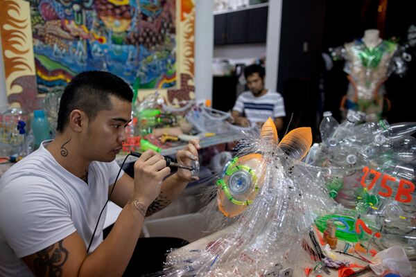 الفنان الفلبيني لييروي نيو (Leeroy New) يرتدي قناعا من صنع يديه، من مواد معاد تدويرها، في ورشة عمله في مدينة كويزون سيتي، الفلبين 28 مايو/ أيار 2020 - سبوتنيك عربي