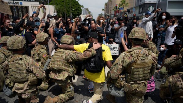 احتجاجات جورج فلويد - عناصر الحرس الأمريكي يقفون على ركبة واحدة في إطار التضامن مع المتظاهرين في لوس أنجلوس، الولايات المتحدة 2 يونيو 2020 - سبوتنيك عربي