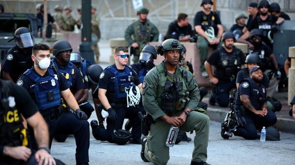 احتجاجات جورج فلويد - عناصر الشرطة الأمريكية يقفون على ركبة واحدة في إطار التضامن مع المتظاهرين في أطلنطا، الولايات المتحدة 1 يونيو 2020 - سبوتنيك عربي