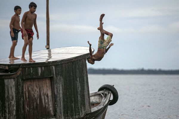 أطفال يقفزون إلى مياه خليج ملاكو، ولاية بارا، البرازيل 30 مايو 2020 - سبوتنيك عربي