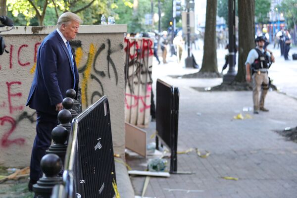 الرئيس الأمريكي دونالد ترامب يقف على خلفية غرافيتي وكتابات في منتزه لافاييت مقابل البيت الأبيض في واشنطن، الولايات المتحدة  1 يونيو 2020 - سبوتنيك عربي