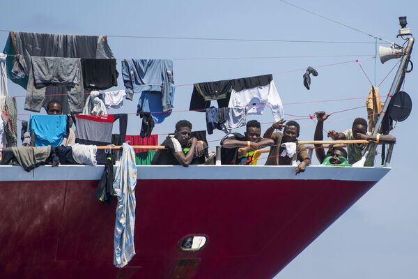 مهاجرون يقومون بنشر غسيلهم على قارب على بعد  20 كم من سواحل مالطا 2 يونيو 2020 - سبوتنيك عربي