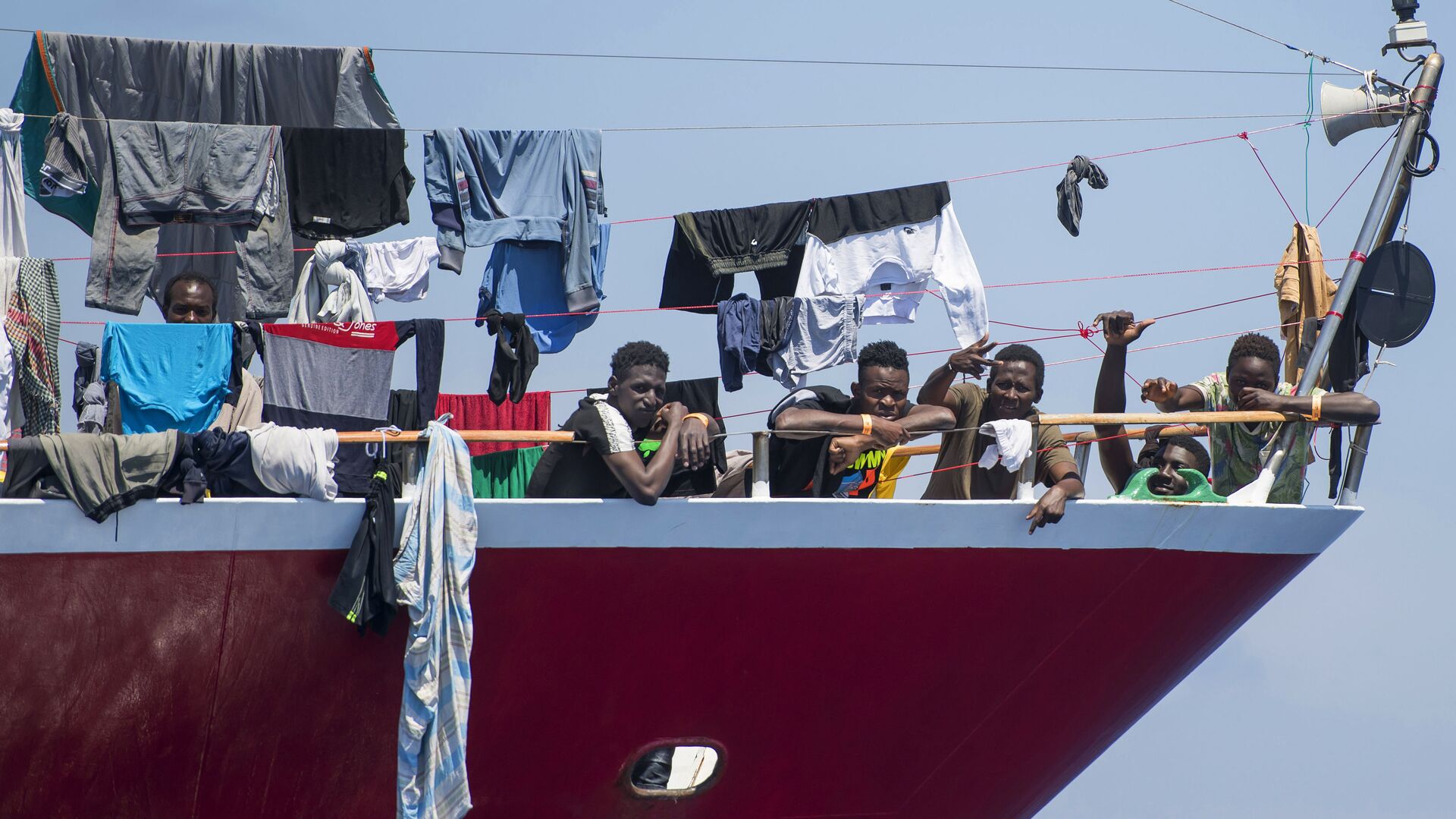 مهاجرون يقومون بنشر غسيلهم على قارب على بعد  20 كم من سواحل مالطا 2 يونيو 2020 - سبوتنيك عربي, 1920, 31.10.2021