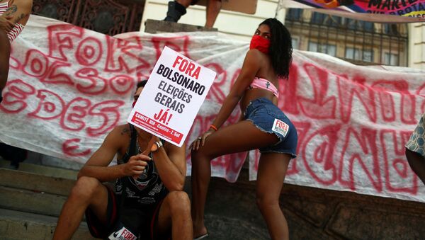 متظاهر يحمل لافتة مكتوب عليها بولسونارو إلى الخارج، الانتخابات العامة الآن! أثناء احتجاجات ضد الرئيس البرازيلي الحالي جويير بولونارو في ريو دي جانيرو، البرازيل، 13 يونيو 2020 - سبوتنيك عربي