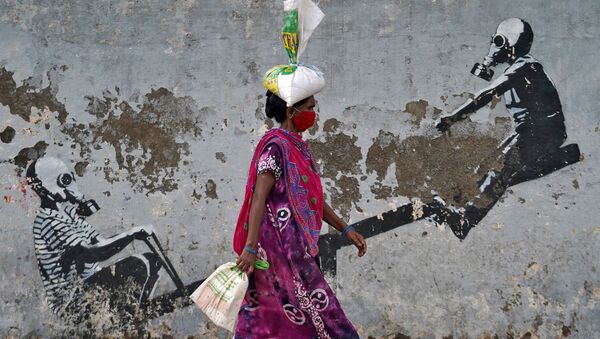 امرأة ترتدي كمامة تسير في أحد شوارع مدينة مومباي، بعد أن أعلنت السلطات المحلية بتخفيف الإغلاق العام بسبب تفشي المرض الفيروسي كوفيد-19، الهند، 12 يونيو 2020 - سبوتنيك عربي