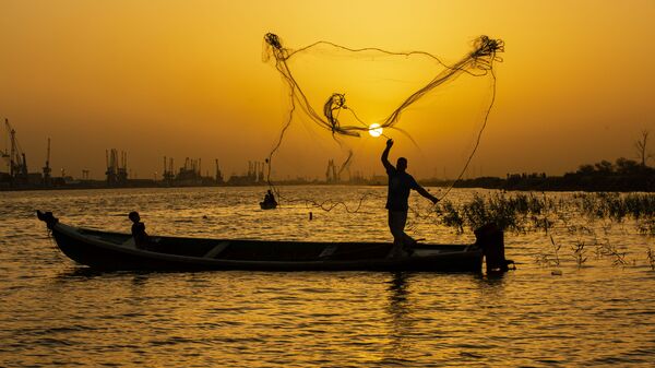 صياد السمك يلقي بشبكته عند الغروب في مياه نهر شط العرب في مدينة البصرة، العراق 12 يونيو 2020 - سبوتنيك عربي