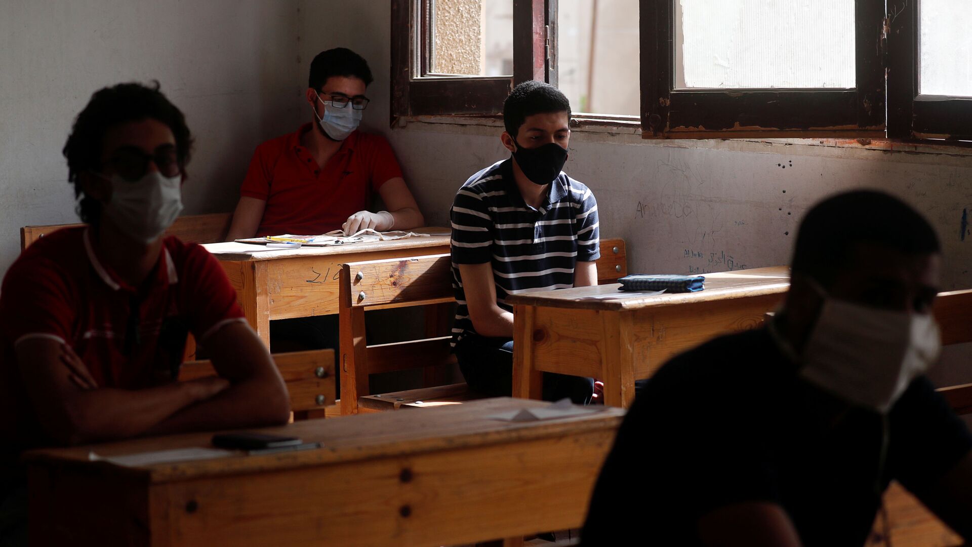 طلاب الثانوية العامة في مصر يرتدون أقنعة واقية أثناء حضورهم في اليوم الأول من الامتحانات وسط مخاوف من تفشي مرض فيروس كورونا - سبوتنيك عربي, 1920, 21.11.2021