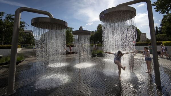 أطفال يلعبون بين نوافير المياه في مدينة فيلنوس، خلال موجة حر تضرب ليتوانيا 19 يونيو 2020 - سبوتنيك عربي