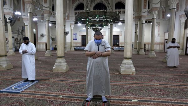 المسلمون الذين يرتدون أقنعة واقية يؤدون وسط علامات التباعد الاجتماعي يؤدون أول صلاة الفجر داخل مسجد صلاح الدين بعد أشهر من الإغلاق - سبوتنيك عربي
