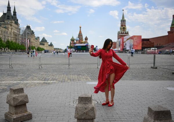 امرأة تلتقط صورة سيلفي على خلفية الساحة الحمراء في يوم مشمس في موسكو، روسيا 10 يونيو 2020 - سبوتنيك عربي