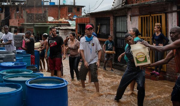 يجمع الناس مياه الشرب في حاويات مختلفة. نظرا لشح في إمدادات المياه، يضطر سكان بعض مناطق مدينة كاراكاس إلى انتظار هطول الأمطار حتى يتمكنوا من الحصول على المياه، فنزويلا 8 يونيو 2020 - سبوتنيك عربي