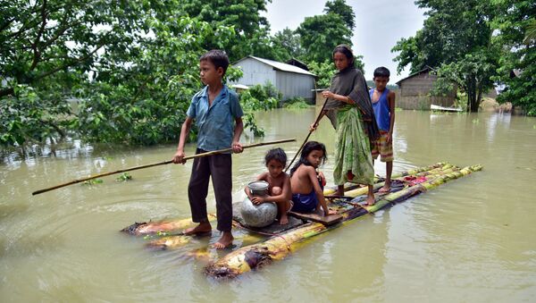 قرويون يجرون طوفًا مؤقتًا عبر حقل غمرته المياه للوصول إلى مكان أكثر أمانًا في قرية مايونغ المتضررة من الفيضانات في منطقة موريغاون، في ولاية آسام الشمالية الشرقية، الهند  29 يونيو 2020. - سبوتنيك عربي