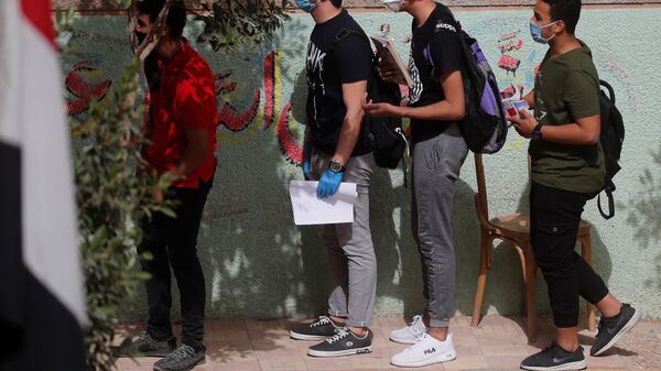 طلاب في الثانوية العامة يرتدون كمامات ينتظرون دورهم في الدخول إلى قاعة الامتحانات النهائية، وسط مخاوف من تفشي مرض كوفيد-19 في القاهرة، مصر، 21 يونيو 2020 - سبوتنيك عربي